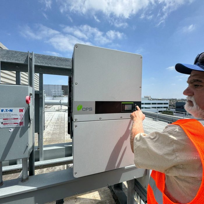 a man in a vest and hat using a touch screen device